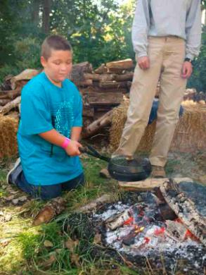 A young man got a chance to cook like it was done in the ‘old days’ at Heritage Day.